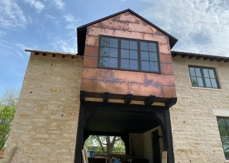 Copper metal panel facade on a stone building for Roof Repair in Hillside
