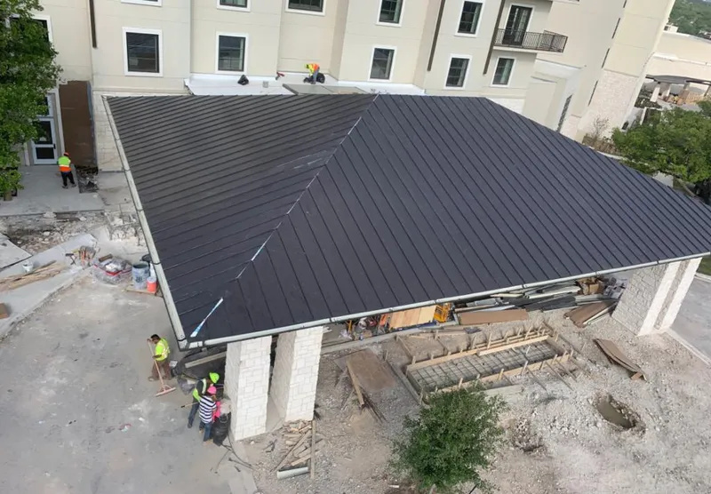 Metal roofing installation team working on a commercial building in Hillside